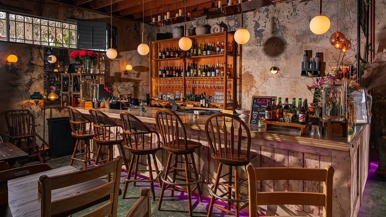 interior of los angeles restaurant with wooden chairs along a bar and rustic design