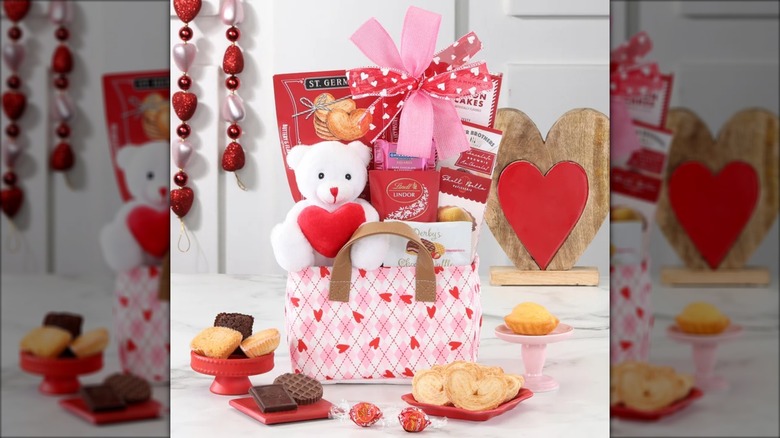 A Valentine's Day Teddy Bear Tote sits on a countertop, with some of the included treats scattered around and valentine decor in the background