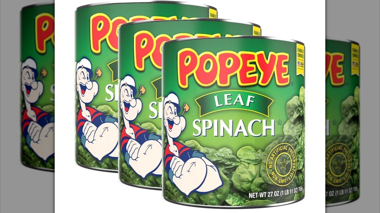 Three cans of Popeye Leaf Spinach lined up