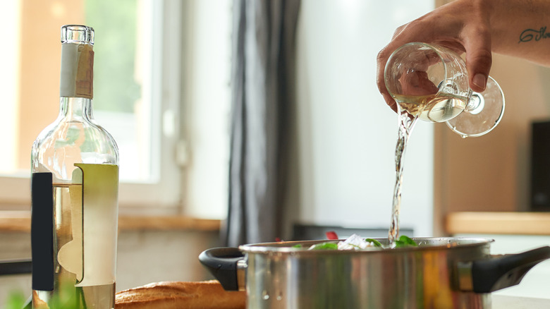 Pouring white wine in pan