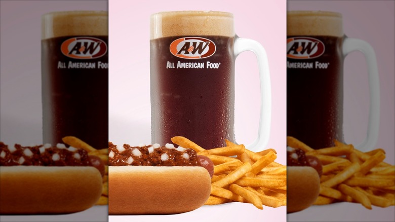 An A&W Coney Dog and a pile of french fries sit in front of a mug of A&W root beer