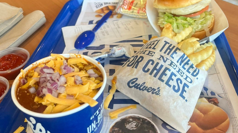A cup of Culver's George's Chili Supreme sits on a restaurant tray with an order of fries and a burger