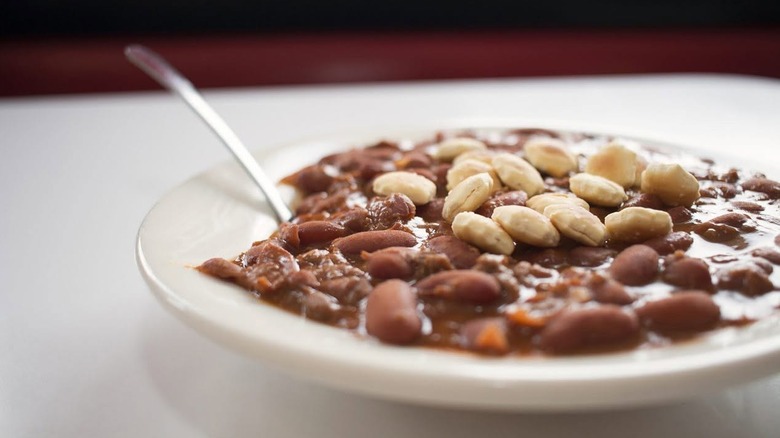 A white dish of Steak 'n Shake chili topped with oyster crackers