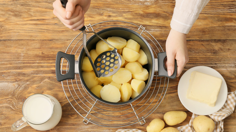 hands about to mash potatoes
