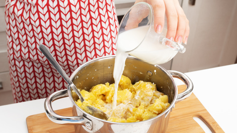pouring milk into mashed potatoes