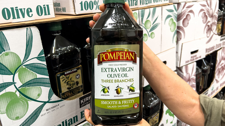 Hands picking up bottle of Pompeian Olive Oil in Costco