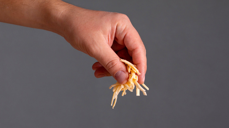 hand sprinkling cheese