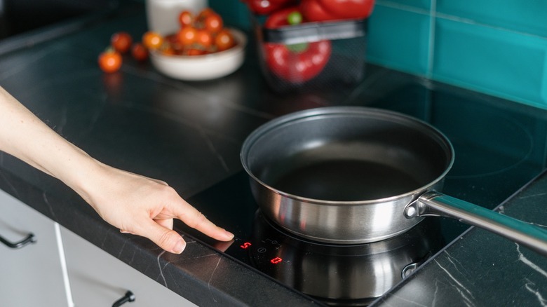 person setting stove temperature