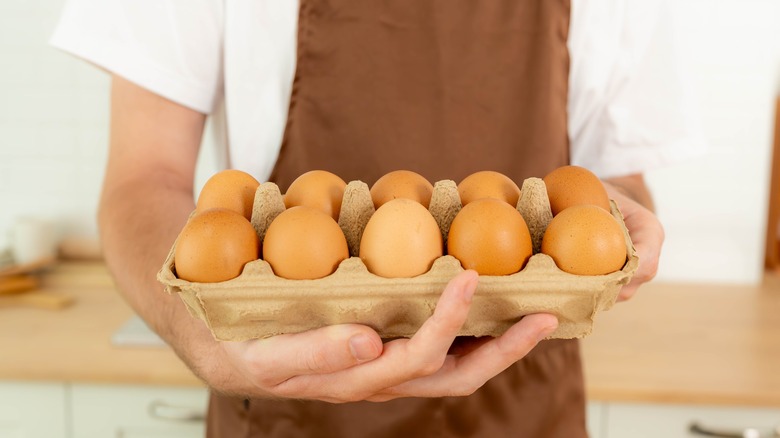person holding egg carton