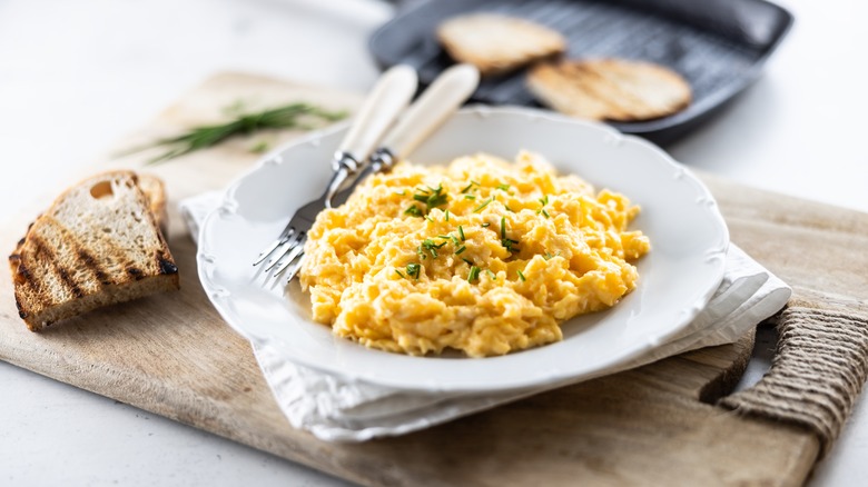 scrambled eggs and toast on board