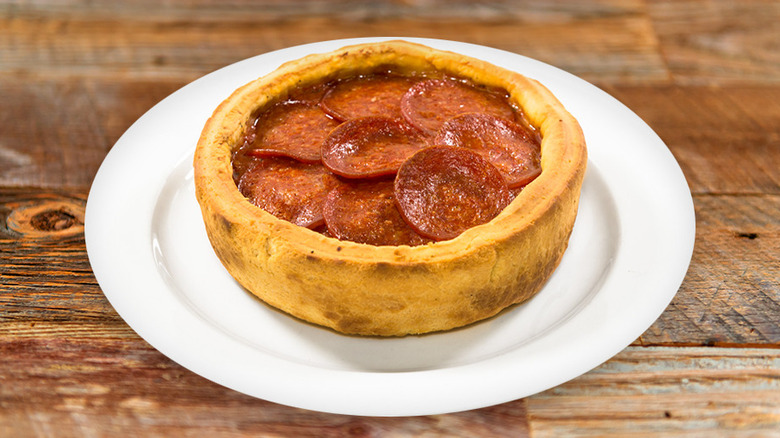 A personal-sized Giordano's Stuffed Deep Dish Pizza with Pepperoni on a white plate.