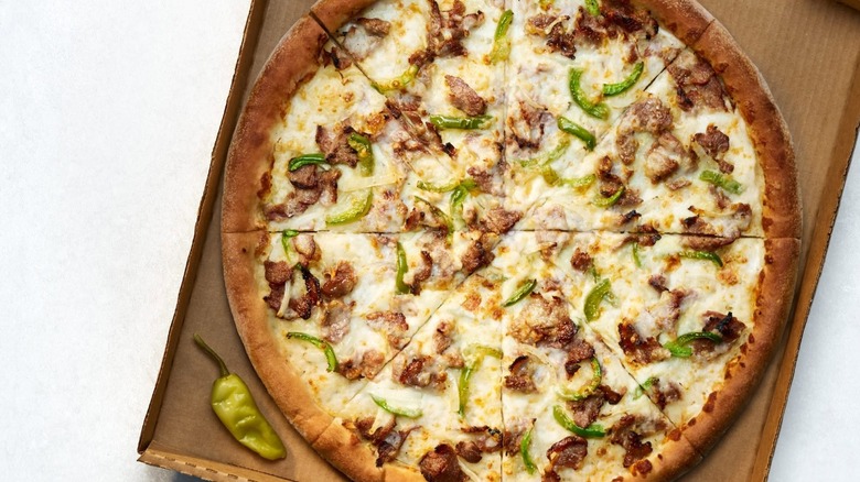 A Papa John's Philly Cheesesteak Pizza in its box on a white surface.