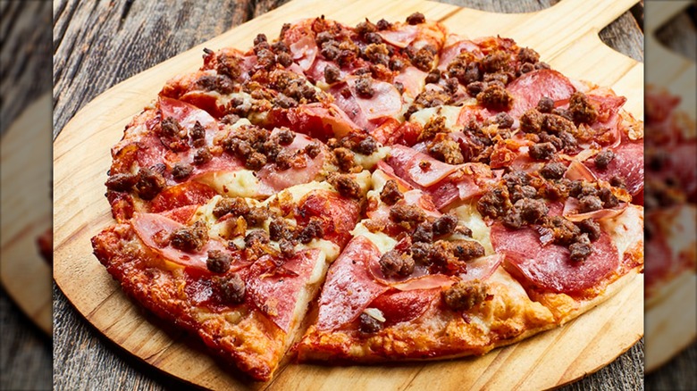 An Ultimate Meat pizza from Shakey's Pizza Parlor sits on a pizza peel