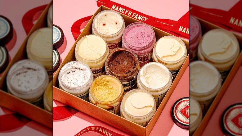 Various glass containers of ice cream sit in a gift box.