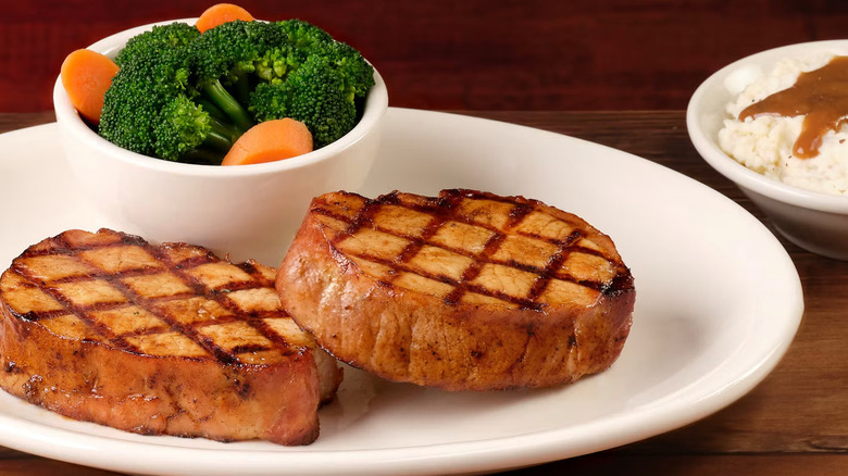 Grilled double pork chops with a side of broccoli and carrots and mashed potatoes with gravy