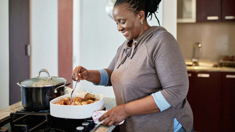 happy woman serving roast potatoes