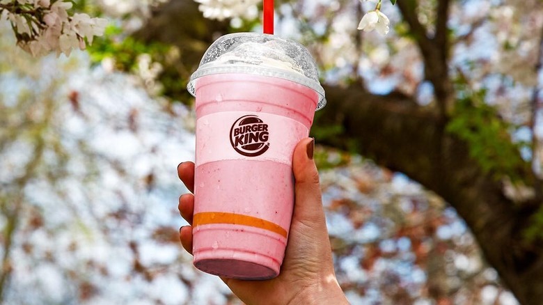 Burger King milkshake in hand in front of tree