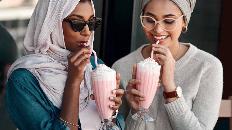 Two women drinking milkshakes