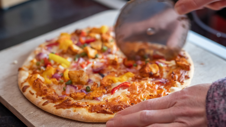 Pizza slicer cutting pizza