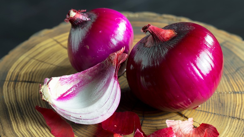 red onions on wooden plate