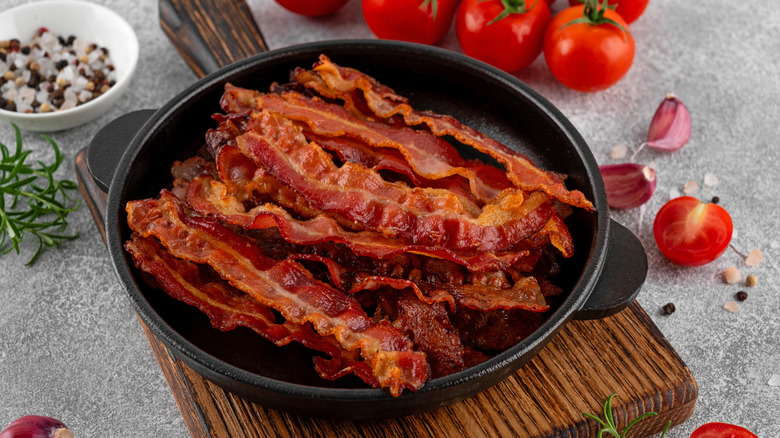crispy bacon in a pan on a cutting board