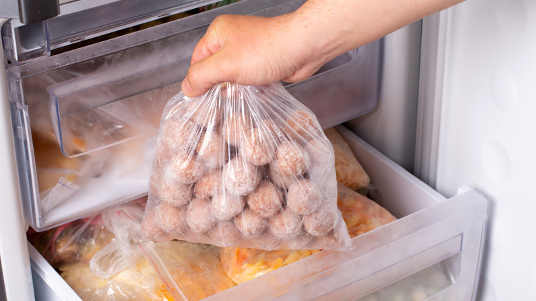 Taking a bag of frozen meatballs out of the freezer