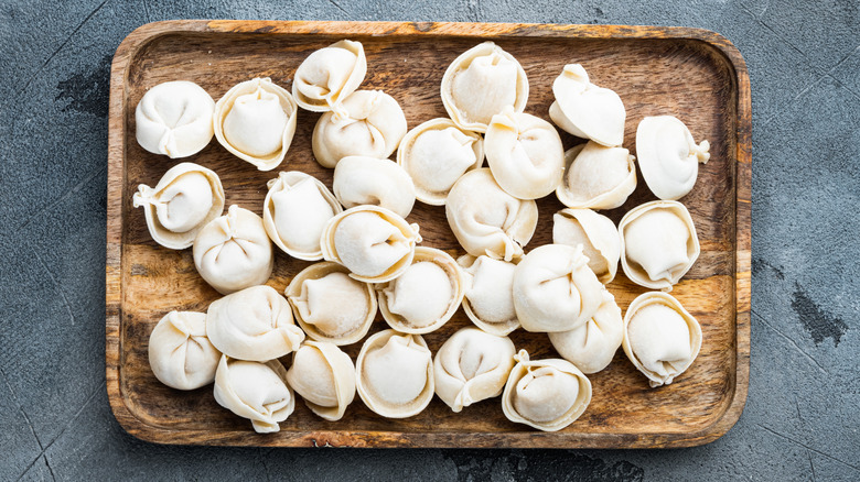 Frozen tortellini on a wooden serving board