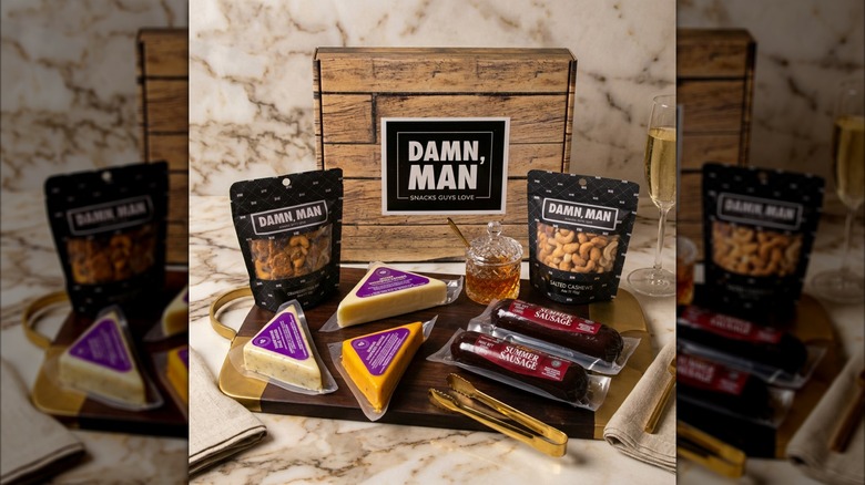 The contents of a Damn, Man Delicatessen Box are spread out on a charcuterie board.