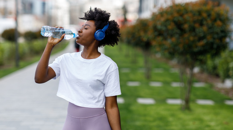 woman drinking from water bottle