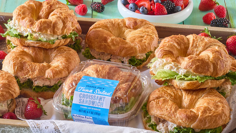 An arrangement of Trader Joe's Tuna Salad Croissant Sandwiches on a wooden tray.