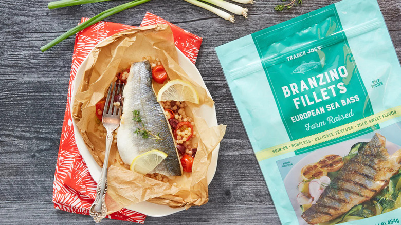 A package of Trader Joe's Branzino Fillets European Sea Bass sits beside a plate of prepared fish.
