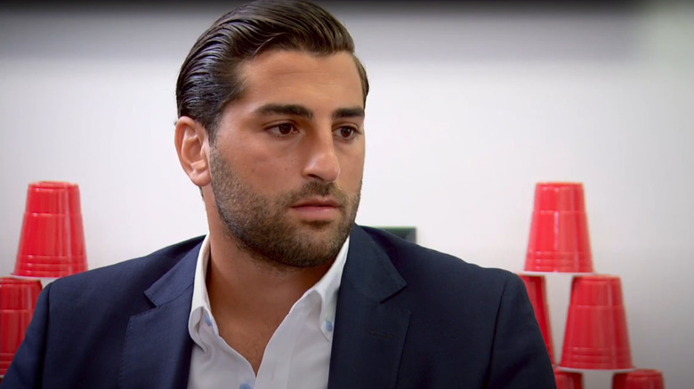 Solomon Fallas sits and looks serious as he talks with Daymond John