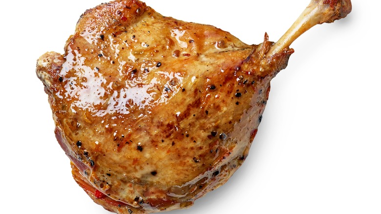 Duck confit leg on white background
