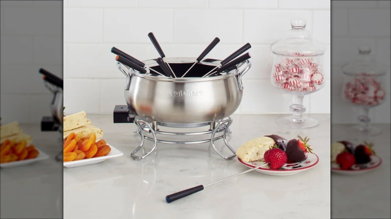A Cuisinart Electric Fondue Set sits on a countertop surrounded by dipping foods