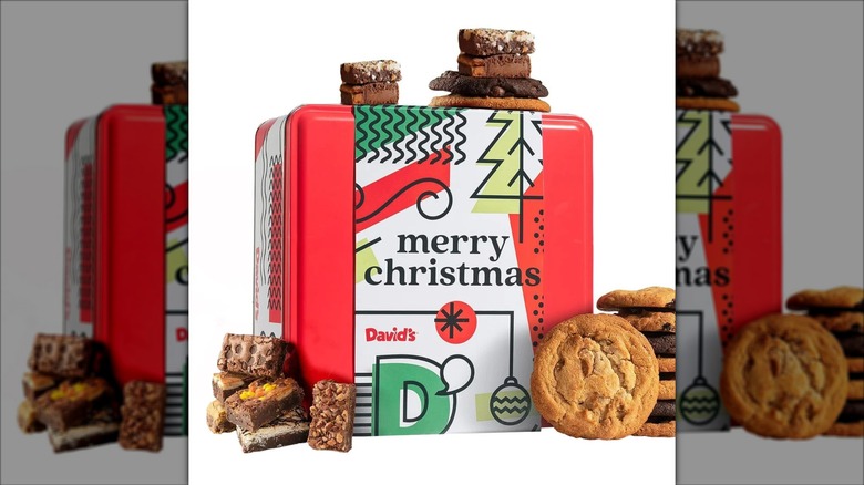A decorative gift tin from David's Cookies is surrounded by cookies and brownies