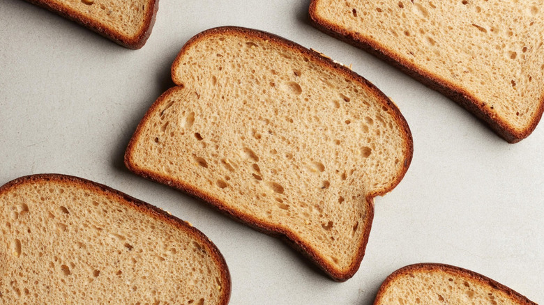 Slices of P28 The Original High Protein Bread on a gray surface.