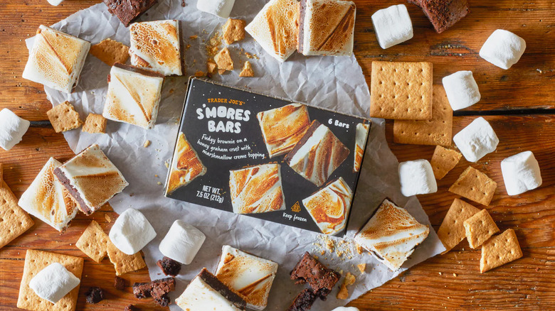 A box of Trader Joe's S'Mores Bars is surrounded by open S'Mores Bars, graham crackers, and marshmallows.
