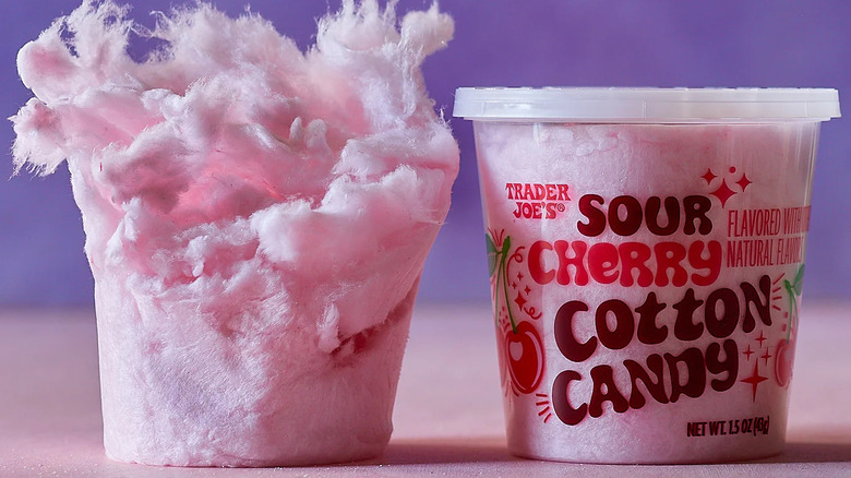 A tub of Trader Joe's Sour Cherry Cotton Candy sits next to a package-less mass of the candy