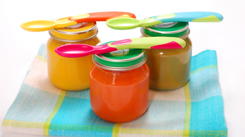 Jars of baby food with spoons