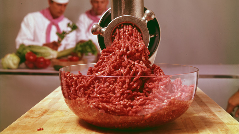Freshly ground beef coming out of a meat grinder