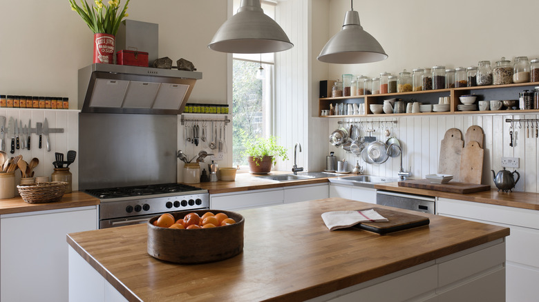 a kitchen island with a bowl of oranges on top