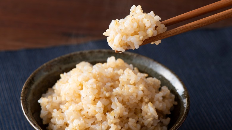 Using chopsticks to eat rice