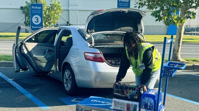 A Sam's Club employee loads up a car in a pickup space