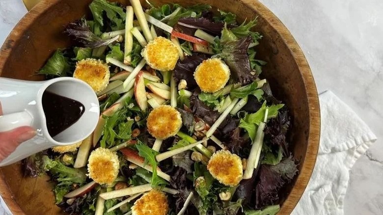 Drizzling dressing over salad