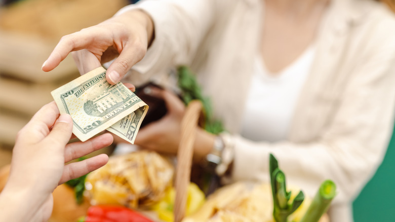 Woman paying for groceries with cash