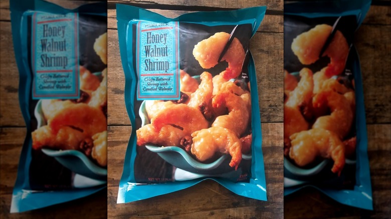 A bag of Trader Joe's Honey Walnut Shrimp on a wooden surface.