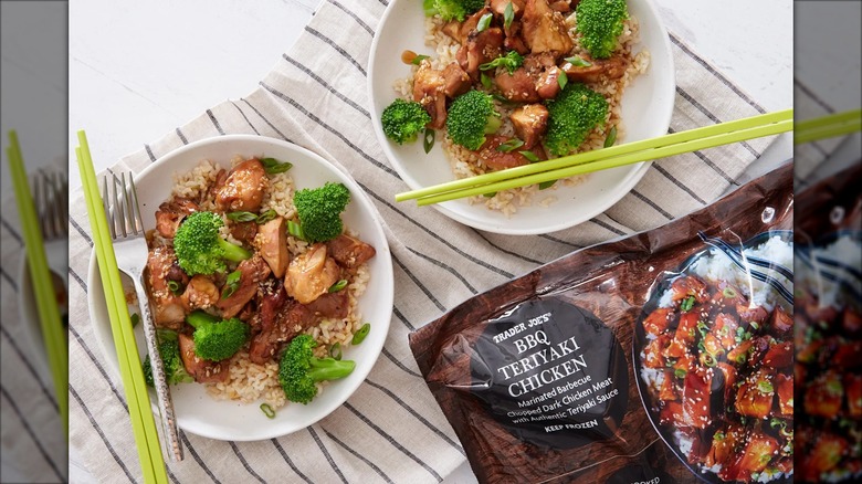 A bag of Trader Joe's BBQ Teriyaki Chicken sits next to plates of the prepared product.