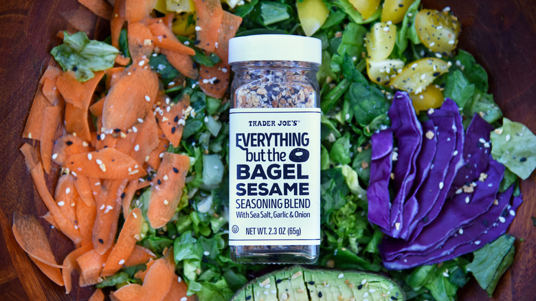 A jar of Everything But the Bagel Sesame Seasoning blend sits on a pile of chopped vegetables