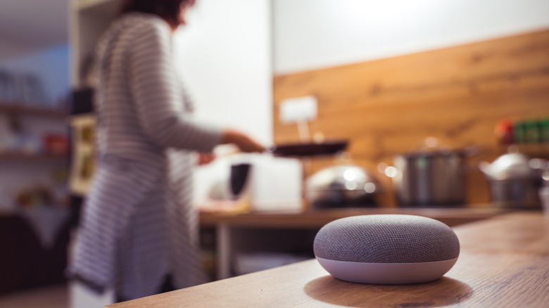 smart speaker and woman cooking in background