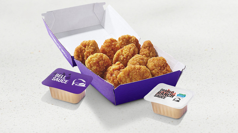 Container of Taco Bell Crispy Chicken Nuggets with two sauces